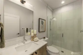 Contemporary bathroom with a frameless glass shower, chic vanity, and carefully curated accents for a luxurious feel.