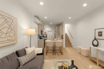 The open floor plan view shows off the beautiful flow from the living area to the kitchen, with sleek wood floors and designer finishes. This home is the epitome of functional style.