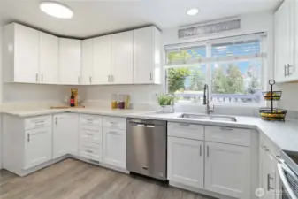 This bright space features ample storage, modern finishes, and backyard views.