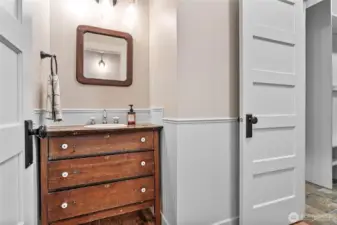 Powder room with 1/2 bath can be accessed from the entry hallway or kitchen.