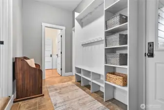Mudroom with built-ins accessible from the garage and additional door to the backyard.