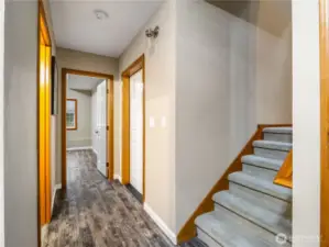 Lower-level showcasing access to the garage, bedroom, and office space, with stairs leading up to the main living level