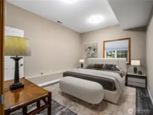 Virtually staged downstairs bedroom featuring a separate walk-in closet and a private bathroom with shower