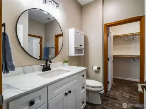 Fully remodeled bathroom featuring a modern vanity, clean, updated finishes, and direct access to the walk-in closet, conveniently located off the downstairs bedroom