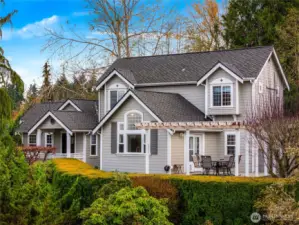 Classic curb appeal with a welcoming front porch, manicured landscaping, and timeless architectural details