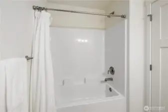 Upper-level full bath with tub and shower combination and simple, low-maintenance design.