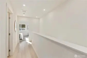 Upper-level hallway connecting bedrooms, bath, and laundry area.