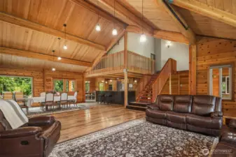 Open concept main floor living area showcasing seamless flow between living room, dining area and kitchen with access to upstairs.