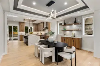 Dining room with buffet and shelves with lighting. Tile wall and coffered ceiling