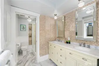 This bright Primary Bathroom has windows for natural light, a tiled walk-in shower, Double Sink and a seperate vanity area area.
