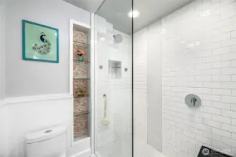 The luxurious Primary Bathroom has a Walk-in Shower with tiled up to the ceiling and built in shelves, and pocket door for privacy. The rest of the bathroom features a  Double Sink Vanity with storage and a completely seperate built-in vanity area area.