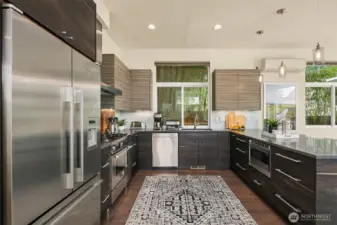 Stainless steel appliances set in custom cabinetry finished with Quartz countertops.