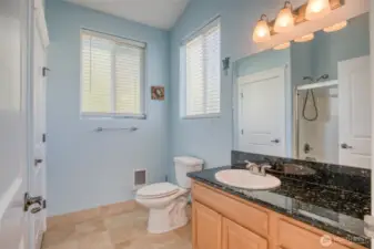 Bathroom has granite countertops that match the kitchen.