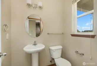 Main floor powder room is convenient and set away from the living space. Photo has been virtually staged.