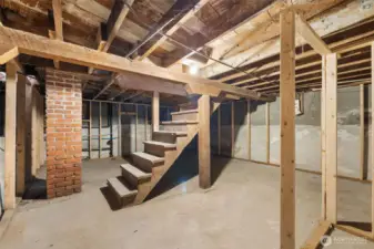 Lower level with laundry plumbing roughed in, framing in place, and walls sealed—ready for your finishing touches.
