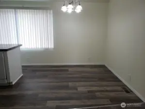A look at the Huge Dining Room from the Living Room with Cathedral Ceilings, Newer Interior Paint. and Vinyl Plank Flooring.
