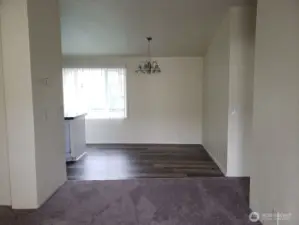 A look at the Huge Dining Room from the Living Room with Newer Carpeting, Cathedral Ceilings, Newer Interior Paint. and Vinyl Plank Flooring.