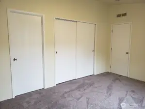 Another Look at the Spacious Primary Master Bedroom with Vaulted Ceiling and Newer Interior Paint and Carpet showing doors to Huge Closet and Full Bath Room.