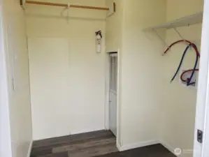 Separate Utility Room has Newer Interior Paint, Trim, Vinyl Plank Flooring, Shelf and Hanging Rod.