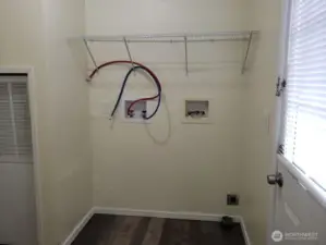 Another Picture of the Separate Utility Room has Newer Interior Paint, Trim, Vinyl Plank Flooring, Shelf Back Door.