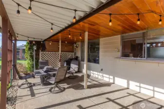 Covered, partially enclosed outdoor living area looks out to the large fenced backyard & is great for year round enjoyment.