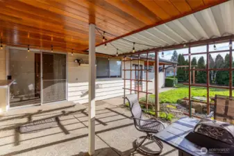 Covered, partially enclosed outdoor living area looks out to the large fenced backyard & is great for year round enjoyment.