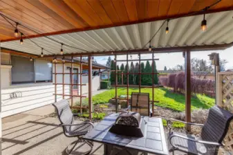 Covered, partially enclosed outdoor living area looks out to the large fenced backyard & is great for year round enjoyment.