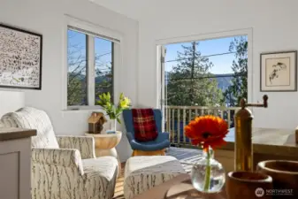Looking toward the sitting area with the French doors open to the streaming sunshine and lake views beyond.