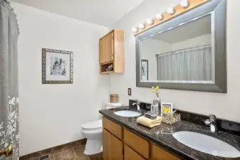 Upstairs main bathroom is bright with double sinks and granite counters. There is spacious linen closet behind the door.