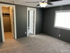 Primary bedroom looking into walk in closet and bathroom.