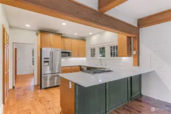 Updated kitchen with wooden cabinetry, stainless steel appliances, and expansive counters.