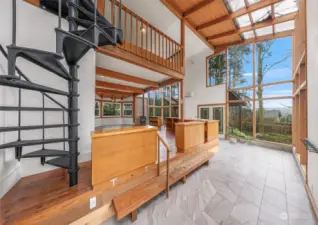 Detailed wooden accents throughout a vaulted great room with a spiral staircase to the upper level.