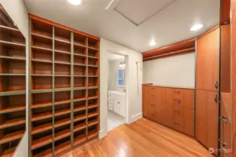 Custom walk-in closet with ample built-in shelving and adjoining en-suite access.