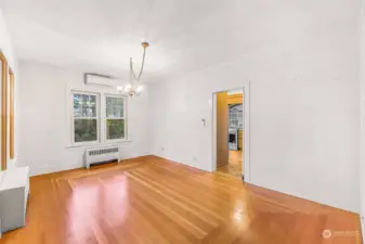 Another view of the dining room showcases its bright and open design, enhanced by the hardwood floors and natural light from multiple windows. The adjacent kitchen is visible through the doorway, providing a convenient flow for hosting and everyday living.