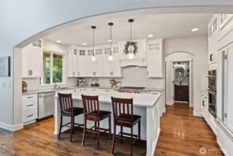 The updated gourmet kitchen is spacious and bright with a graceful arched entry.