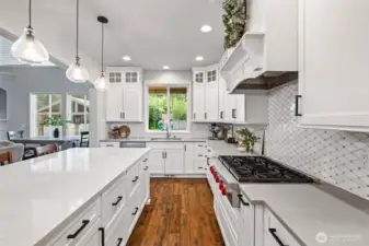 This lovely kitchen has it all! Wolf cooktop, custom tile backsplash, hardwood floors, spacious island and so much storage!