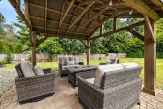 The covered gazebo has pavers and party lights. Add seating and a firepit for year round entertaining.