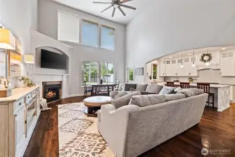 Step into the two-story family room with a wall of windows for natural light, cozy gas fireplace, and hardwood floors. Open to the kitchen for easy entertaining.