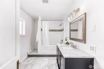 Main floor bathroom off of primary bedroom. Large space with new vanity, tub, and toilet.