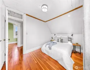 Large upstairs bedroom with a full wall of built in closets and large West facing windows