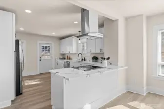 Stunning, completely remodeled kitchen with quartz counters, stainless appliances, opens to dining and living