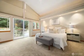 Primary Bedroom looking over the deck with Hot Tub.