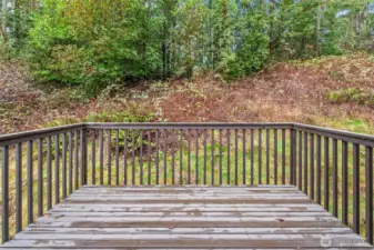 Back deck off the dining room is perfect for barbeques or quiet coffee in the morning. The natural vegetation of the greenbelt behind the house provides ideal privacy.
