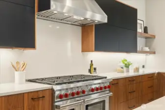 8-burner Wolf gas range and two ovens with full slab backsplash