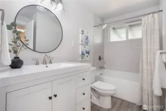 Fully remodeled full bath on upper floor w/new vinyl plank flooring, tile shower surround, vanity, paint, lighting - fresh & inviting!