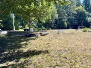 From the rear of the lot, the circular drive, parking pad, propane tank, and water source are visible.