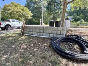 The retaining wall allows for a designated parking pad.  120 gallon propane tank in included with property.  30 amp RV hook up and 200 amp power for a home is already on the property.