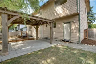 Fully fenced backyard offers a blend of open lawn, patio, and deck with easy access to the attached two car garage.