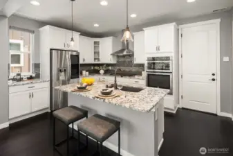 Kitchen with slab granite countertops and SS appliances