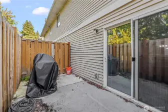 The fenced concrete patio includes a secure gate, creating a private outdoor retreat. It’s the perfect spot for grilling, lounging, or simply enjoying fresh air.